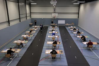 GERMANY PANDEMIC EDUCATION CORONAVIRUS epa08416458 Students write their final examination paper on biology, in a sports hall, which has been converted into a classroom in accordance with the latest German health regulations, at the Privat High School Stadtkrone (PGS) in Dortmund, Germany, 12 May 2020. Due to the ongoing coronavirus pandemic, the final secondary-school examinations in the German state of North Rhine-Westphalia are starting with strict safety precautions. EPA/FRIEDEMANN VOGEL
