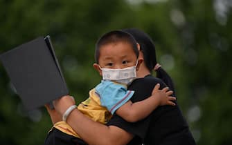 A mother holds his son next to Yangtze River in Wuhan, in Chinas central Hubei province on May 12, 2020. - Wuhan plans to conduct coronavirus tests on the Chinese city's entire population after new cases emerged for the first time in weeks in the cradle of the global pandemic, state media reported on May 12. (Photo by Hector RETAMAL / AFP) (Photo by HECTOR RETAMAL/AFP via Getty Images)
