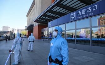 Police officers clad in protective suits stand guard outside Jilin city's railway station in China's Jilin province on May 13, 2020. - A northeastern Chinese city has partially shut its borders and cut off transport links after the emergence of a local coronavirus cluster that has fuelled growing fears of a second wave of infections in China. (Photo by STR / AFP) / China OUT (Photo by STR/AFP via Getty Images)