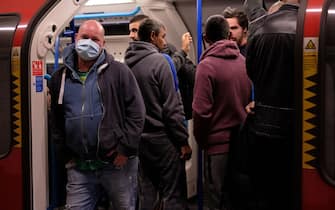 1212829505 Commuters wearing PPE (personal protective equipment), including a face mask as a precautionary measure against COVID-19, travel in the morning rush hour on TfL (Transport for London) London underground Victoria Line trains from Finsbury Park towards central London on May 13, 2020, as people start to return to work after COVID-19 lockdown restrictions were eased. - Britain's economy shrank two percent in the first three months of the year, rocked by the fallout from the coronavirus pandemic, official data showed Wednesday, with analysts predicting even worse to come. Prime Minister Boris Johnson began this week to relax some of lockdown measures in order to help the economy, despite the rising death toll, but he has also stressed that great caution is needed. (Photo by Isabel INFANTES / AFP) (Photo by ISABEL INFANTES/AFP via Getty Images)
