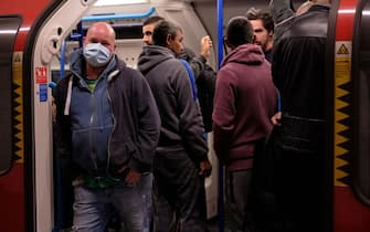 Commuters wearing PPE (personal protective equipment), including a face mask as a precautionary measure against COVID-19, travel in the morning rush hour on TfL (Transport for London) London underground Victoria Line trains from Finsbury Park towards central London on May 13, 2020, as people start to return to work after COVID-19 lockdown restrictions were eased. - Britain's economy shrank two percent in the first three months of the year, rocked by the fallout from the coronavirus pandemic, official data showed Wednesday, with analysts predicting even worse to come. Prime Minister Boris Johnson began this week to relax some of lockdown measures in order to help the economy, despite the rising death toll, but he has also stressed that great caution is needed. (Photo by Isabel INFANTES / AFP) (Photo by ISABEL INFANTES/AFP via Getty Images)