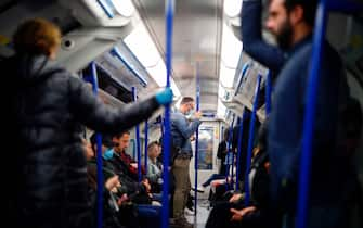 Commuters wearing PPE (personal protective equipment), including a face mask as a precautionary measure against COVID-19, travel in the morning rush hour on TfL (Transport for London) London underground Victoria Line trains from Walthamstow towards central London on May 13, 2020, as people start to return to work after COVID-19 lockdown restrictions were eased. - Britain's economy shrank two percent in the first three months of the year, rocked by the fallout from the coronavirus pandemic, official data showed Wednesday, with analysts predicting even worse to come. Prime Minister Boris Johnson began this week to relax some of lockdown measures in order to help the economy, despite the rising death toll, but he has also stressed that great caution is needed. (Photo by Tolga Akmen / AFP) (Photo by TOLGA AKMEN/AFP via Getty Images)