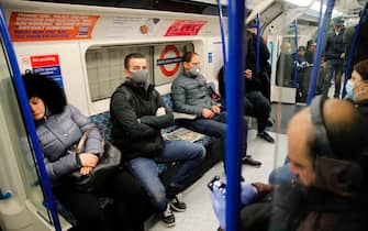 Commuters wearing PPE (personal protective equipment), including a face mask as a precautionary measure against COVID-19, travel in the morning rush hour on TfL (Transport for London) London underground Victoria Line trains from King's Cross St Pancras towards central London on May 13, 2020, as people start to return to work after COVID-19 lockdown restrictions were eased. - Britain's economy shrank two percent in the first three months of the year, rocked by the fallout from the coronavirus pandemic, official data showed Wednesday, with analysts predicting even worse to come. Prime Minister Boris Johnson began this week to relax some of lockdown measures in order to help the economy, despite the rising death toll, but he has also stressed that great caution is needed. (Photo by Tolga AKMEN / AFP) (Photo by TOLGA AKMEN/AFP via Getty Images)