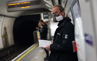 A commuter wearing PPE (personal protective equipment), including a face mask as a precautionary measure against COVID-19, travel waits on th eplatform at Oxford Circus to travel on a TfL (Transport for London) London underground Victoria Line train in central London on May 13, 2020, as people start to return to work after COVID-19 lockdown restrictions were eased. - Britain's economy shrank two percent in the first three months of the year, rocked by the fallout from the coronavirus pandemic, official data showed Wednesday, with analysts predicting even worse to come. Prime Minister Boris Johnson began this week to relax some of lockdown measures in order to help the economy, despite the rising death toll, but he has also stressed that great caution is needed. (Photo by ISABEL INFANTES / AFP) (Photo by ISABEL INFANTES/AFP via Getty Images)
