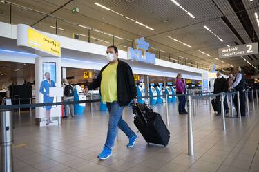 Travelers wearing a face mask are seen at the KLM check-in area of Amsterdam Schiphol airport on May 11, 2020, as the lockdown introduced two months ago to fight the spread of the Covid-19 disease caused by the novel coronavirus starts to ease. - KLM airlines makes the wearing of face masks mandatory. (Photo by Evert ELZINGA / ANP / AFP) / Netherlands OUT (Photo by EVERT ELZINGA/ANP/AFP via Getty Images)