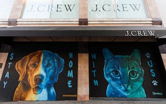VANCOUVER, BRITISH COLUMBIA - MAY 06: Murals of a dog and a cat reading "Stay Home" and "With Us" is on display on boarded up windows of J.Crew storefront on Robson Street during the coronavirus pandemic on May 06, 2020 in Vancouver, Canada. Robson Street, normally a popular tourist area in Vancouver is quiet as all non-essential retail has been closed to slow the spread of COVID-19. (Photo by Andrew Chin/Getty Images)