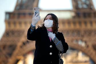 PARIS, FRANCE - MARCH 30: A woman wearing a mask and protective gloves takes a selfie in front of the Eiffel Tower during the Coronavirus epidemic (CODIV 19) on March 30, 2020 in Paris, France. The country is issuing fines for people caught violating its nationwide lockdown measures intended to stop the spread of COVID-19. The pandemic has spread to at least 182 countries, claiming over 30,000 lives and infecting hundreds of thousands more. (Photo by Chesnot/Getty Images)