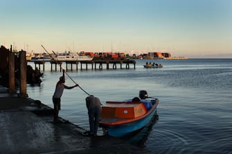 1180673130 SOLOMON ISLANDS - OCTOBER 12: A man arrives at the Honiara Central Markets by boat as performers from the 'Solomon Islands Cultural Group' prepare to leave the island nation to attend the Royal Edinburgh Military Tattoo on October 12, 2019 in Honiara, Solomon Islands. The Australian Defence Force is picking up performers from the Pacific Islands to travel to Sydney to participate in the Royal Edinburgh Military Tattoo. The Sydney production will be the largest Tattoo in its 69-year history with 1521 pipers, drummers, dancers, military musicians and performers taking part. The Royal Edinburgh Military Tattoo runs from 17-19 October in Sydney. (Photo by Lisa Maree Williams/Getty Images)