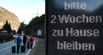 (FILE) GERMANY BORDER CONTROLS CORONAVIRUS epa08418768 (FILE) - A group of tourists walks past a warning sign reading 'Please stay at home for two weeks', at the border between Germany and Austria, in Scharnitz, Germany, 16 March 2020 (reissued 13 May 2020). Media reports state on 13 May 2020 that Germany is planning to partially ease border controls as early as 16 May 2020, following a decision of the Cabinet. At the same time, Austria is planning to reopen the border with Germany as early as 15 June, media added. EPA/PHILIPP GUELLAND *** Local Caption *** 55955912