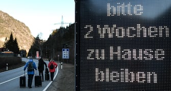 epa08418768 (FILE) - A group of tourists walks past a warning sign reading 'Please stay at home for two weeks', at the border between Germany and Austria, in Scharnitz, Germany, 16 March 2020 (reissued 13 May 2020). Media reports state on 13 May 2020 that Germany is planning to partially ease border controls as early as 16 May 2020, following a decision of the Cabinet. At the same time, Austria is planning to reopen the border with Germany as early as 15 June, media added.  EPA/PHILIPP GUELLAND *** Local Caption *** 55955912