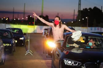 BONN, GERMANY - MAY 15: Supporters reacts from their cars as German singer Heino performs on stage during the first BonnLive drive-in concert at Am Westwerk during the Coronavirus crisis on May 15, 2020 in Bonn, Germany. The project "BonnLive Autokonzerte" is a series of drive-in concerts with musicians of different genres. The area provides space for about 200 cars. Drive-ins are becoming an increasingly popular venue for singers, theater groups, and even churches to hold events while adhering to Coronavirus lockdown measures. Two peoples are allowed to attend per vehicle and the attendees must remain in their cars. (Photo by Andreas Rentz/Getty Images)