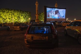 epa08426922 People watch a movie from inside their cars during the Drive-In Festival at Place des Quinconces in Bordeaux, France, France, 16 May 2020 (issued 17 May 2020). The festival opened with the movie Hippocrate of director Thomas Rilti, a tribute to caregivers who risk their lives during the coronavirus pandemic. The event runs through to 24 May 2020 before moving to Marseille.  EPA/CAROLINE BLUMBERG