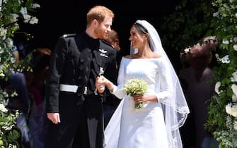 TOPSHOT - Britain's Prince Harry, Duke of Sussex and his wife Meghan, Duchess of Sussex emerge from the West Door of St George's Chapel, Windsor Castle, in Windsor, on May 19, 2018 after their wedding ceremony. (Photo by Ben STANSALL / various sources / AFP)        (Photo credit should read BEN STANSALL/AFP via Getty Images)