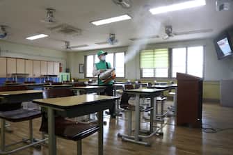 SEOUL, SOUTH KOREA - MAY 19: A disinfection worker sprays anti-septic solution at classroom to prevent the spread of the coronavirus (COVID-19) ahead of school re-opening at Yeouido girl's high school on May 19, 2020 in Seoul, South Korea. Senior high school students are able to return to school from tomorrow, as South Koreans take measures to protect themselves against the spread of coronavirus. South Korea's education ministry announced plans to re-open schools starting for senior high school students, more than two months after schools were closed in a precautionary measure against the coronavirus. According to the Korea Center for Disease Control and Prevention, 13 new cases were reported. The total number of infections in the nation tallies at 11,078. (Photo by Chung Sung-Jun/Getty Images)