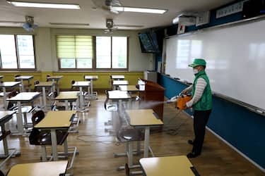 SEOUL, SOUTH KOREA - MAY 19: A disinfection worker sprays anti-septic solution at classroom to prevent the spread of the coronavirus (COVID-19) ahead of school re-opening at Yeouido girl's high school on May 19, 2020 in Seoul, South Korea. Senior high school students are able to return to school from tomorrow, as South Koreans take measures to protect themselves against the spread of coronavirus. South Korea's education ministry announced plans to re-open schools starting for senior high school students, more than two months after schools were closed in a precautionary measure against the coronavirus. According to the Korea Center for Disease Control and Prevention, 13 new cases were reported. The total number of infections in the nation tallies at 11,078. (Photo by Chung Sung-Jun/Getty Images)