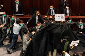HONG KONG, CHINA - MAY 18: Pro democracy and pro Beijing lawmakers scuffle at the House Committee's election of chairpersons, presided by pro-Beijing lawmaker Chan Kin Por at the Legislative Council  on May 18, 2020 in Hong Kong, China. Pro-democracy legislators were dragged out of the chamber by security guards as the two camps fought to control the House Committee which has been at a standstill for months.(Photo by Anthony Kwan/Getty Images)