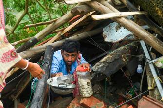 TOPSHOT - Villagers salvage items from their house damaged by cyclone Amphan in Midnapore, West Bengal, on May 21, 2020. - The strongest cyclone in decades slammed into Bangladesh and eastern India on May 20, sending water surging inland and leaving a trail of destruction as the death toll rose to at least nine. (Photo by Dibyangshu SARKAR / AFP) (Photo by DIBYANGSHU SARKAR/AFP via Getty Images)