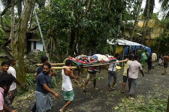 Residents carry Tapas Pramanik (C), 41, after his leg got broken by a tree fall the night before, in search of an ambulance or vehicle to take him to the hospital, following the landfall of cyclone Amphan in Khejuri area of Midnapore, West Bengal, on May 21, 2020. - At least 22 people died as the fiercest cyclone to hit parts of Bangladesh and eastern India this century sent trees flying and flattened houses, with millions crammed into shelters despite the risk of coronavirus. (Photo by Dibyangshu SARKAR / AFP) (Photo by DIBYANGSHU SARKAR/AFP via Getty Images)