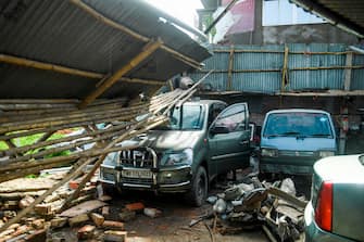 A man checks cars in a garage damaged by cyclone Amphan in Satkhira on May 21, 2020. - The strongest cyclone in decades slammed into Bangladesh and eastern India on May 20, sending water surging inland and leaving a trail of destruction as the death toll rose to at least nine. (Photo by Munir UZ ZAMAN / AFP) (Photo by MUNIR UZ ZAMAN/AFP via Getty Images)