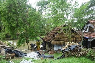 A woman salvages items from her house damaged by cyclone Amphan in Midnapore, West Bengal, on May 21, 2020. - The strongest cyclone in decades slammed into Bangladesh and eastern India on May 20, sending water surging inland and leaving a trail of destruction as the death toll rose to at least nine. (Photo by Dibyangshu SARKAR / AFP) (Photo by DIBYANGSHU SARKAR/AFP via Getty Images)