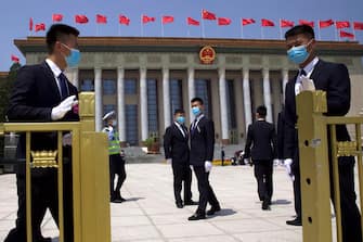 epa08436765 Chinese security officials wear face masks as they stand guard outside the Great Hall of the People after the opening session of China's National People's Congress (NPC) at the Great Hall of the People in Beijing, China, 22 May 2020. China held the Chinese People's Political Consultative Conference (CPPCC) on 21 May and will hold the National People's Congress (NPC) on 22 May, after the two major political meetings initially planned to be held in March 2020 were postponed amid the ongoing coronavirus COVID-19 pandemic.  EPA/Ng Han Guan / POOL