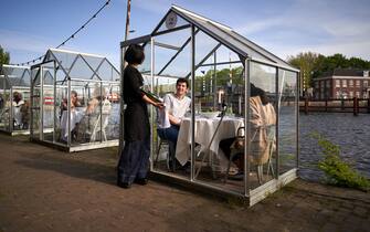 A Dutch restaurant restaurant has come up with a way for people to dine in public during the coronavirus pandemic. Eten Restaurant, part of the Mediamatic Biotoop centre in Amsterdam, has tested greenhouse-like booths for customers to eat in, keeping them protected from contracting COVID-19 from other diners. Amsterdam, Netherlands, May 18, 2020. Photo by Robin Utrecht/ABACAPRESS.COM (Utrecht Robin/ABACAPRESS.COM / IPA/Fotogramma, Amsterdam - 2020-05-18) p.s. la foto e' utilizzabile nel rispetto del contesto in cui e' stata scattata, e senza intento diffamatorio del decoro delle persone rappresentate