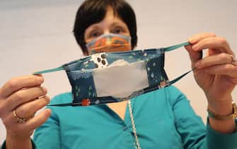 A woman shows a mouth masks with a transparent window for deaf people who do lipreading, at a sheltered workshop (maatwerkbedrijf - entreprise de travail adapte) in Evere, Brussels, on May 15, 2020 amid the pandemic of novel coronavirus (COVID-19). - Belgium is in its ninth week of confinement. (Photo by BRUNO FAHY / Belga / AFP) / Belgium OUT (Photo by BRUNO FAHY/Belga/AFP via Getty Images)