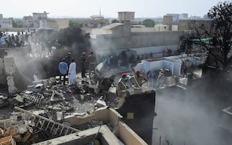 Rescue workers search for victims at the site after a Pakistan International Airlines aircraft crashed at a residential area in Karachi on May 22, 2020. - A Pakistani passenger plane with nearly 100 people on board crashed into a residential area of the southern city of Karachi on May 22. (Photo by Asif HASSAN / AFP) (Photo by ASIF HASSAN/AFP via Getty Images)