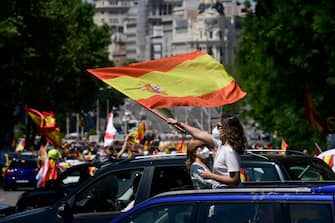 1214798256 Demonstrators wave Spanish flags during a "caravan for Spain and its freedom" protest by far-right party Vox against the Spanish government in Madrid on May 23, 2020. - Spain, one of the most affected countries in the world by the novel coronavirus with 28,628 fatalities, has extended until June 6 the state of emergency which significantly limits the freedom of movement to fight the epidemic. The left-wing government's management of the crisis has drawn a barrage of criticism from righ-wing parties who have denounced its "brutal confinement". (Photo by JAVIER SORIANO / AFP) (Photo by JAVIER SORIANO/AFP via Getty Images)