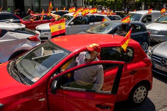 MADRID, SPAIN - MAY 23: People hold Spanish flags as they take part on an in-vehicle protest against the Spanish government on May 23, 2020 in Madrid, Spain. Far right wing VOX party has called for in-vehicle protests across Spain against the Spanish government's handling of the Covid-19 pandemic. Spain has imposed some of the tightest restrictions across the world to contain the spread of the virus, but measures are now easing. Most of the Spanish population supports the lockdown according to a survey. (Photo by Pablo Blazquez Dominguez/Getty Images)
