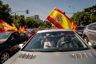 MADRID, SPAIN - MAY 23: People hold Spanish flags as they take part on an in-vehicle protest against the Spanish government on May 23, 2020 in Madrid, Spain. Far right wing VOX party has called for in-vehicle protests across Spain against the Spanish government's handling of the Covid-19 pandemic. Spain has imposed some of the tightest restrictions across the world to contain the spread of the virus, but measures are now easing. Most of the Spanish population supports the lockdown according to a survey. (Photo by Pablo Blazquez Dominguez/Getty Images)