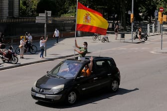 Demonstrators wave a Spanish flag from inside a car during a "caravan for Spain and its freedom" protest by far-right party Vox in Barcelona on May 23, 2020. - Spain, one of the most affected countries in the world by the novel coronavirus with 28,628 fatalities, has extended until June 6 the state of emergency which significantly limits the freedom of movement to fight the epidemic. The left-wing government's management of the crisis has drawn a barrage of criticism from righ-wing parties who have denounced its "brutal confinement". (Photo by Pau Barrena / AFP) (Photo by PAU BARRENA/AFP via Getty Images)