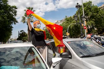 BARCELONA, SPAIN - MAY 23: A protester waves a Spanish flag from her car on May 23, 2020 in Barcelona, Spain. The far-right political party Vox has called for demonstrations in the Spanish province capitals with the slogan; Caravan for Spain and its freedom. The anti-government demonstration is by car to minimize the risks of contagion from Covid. Some parts of Spain have entered the so-called "Phase One" or "Phase Two" transitions from its coronavirus lockdown, allowing many shops to reopen as well as restaurants who serve customers outdoors. Locations that were harder hit by coronavirus (Covid-19), such as Madrid and Barcelona, remain in a stricter quarantine. (Photo by Manuel Medir/Getty Images)