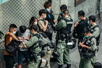 HONG KONG, CHINA - MAY 27: Pedestrians are being stop and search on a street in Central district ahead of the controversial national anthem law on May 27, 2020 in Hong Kong. Chinese Premier Li Keqiang said on Friday during the National People's Congress that Beijing would establish a sound legal system and enforcement mechanism for safeguarding national security in Hong Kong. (Photo by Anthony Kwan/Getty Images)