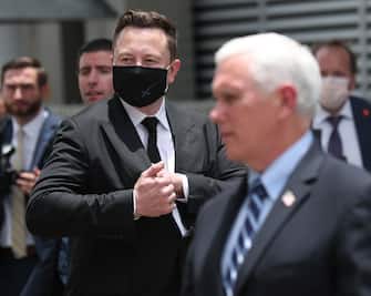 CAPE CANAVERAL, FLORIDA - MAY 27: SpaceX founder Elon Musk (L) wears a face mask while standing next to U.S. Vice President Mike Pence after NASA astronauts Bob Behnken and Doug Hurley walked out of the Operations and Checkout Building on their way to the SpaceX Falcon 9 rocket with the Crew Dragon spacecraft on launch pad 39A at the Kennedy Space Center on May 27, 2020 in Cape Canaveral, Florida. The inaugural flight will be the first manned mission since the end of the Space Shuttle program in 2011 to be launched into space from the United States.  (Photo by Joe Raedle/Getty Images)
