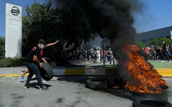 1215809401 Nissan employees burn tyres in front of the Japanese cars manufacturer's plant in Barcelona on May 28, 2020, as they protest against the factory closure. - Japanese carmaker Nissan has decided to shut its factory in Barcelona where 3,000 people are employed, the Spanish government said today. (Photo by LLUIS GENE / AFP) (Photo by LLUIS GENE/AFP via Getty Images)