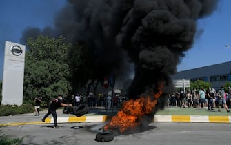 Nissan employees burn tyres in front of the Japanese cars manufacturer's plant in Barcelona on May 28, 2020, as they protest against the factory closure. - Japanese carmaker Nissan has decided to shut its factory in Barcelona where 3,000 people are employed, the Spanish government said today. (Photo by LLUIS GENE / AFP) (Photo by LLUIS GENE/AFP via Getty Images)