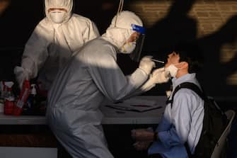 A health worker administers a swab at a temporary COVID-19 novel coronavirus testing centre in Bucheon, south of Seoul, on May 27, 2020. - South Korea reported its biggest jump in coronavirus infections in seven weeks on May 27, driven by a fresh cluster at an e-commerce warehouse on Seoul's outskirts, as millions more pupils went back to school. (Photo by Ed JONES / AFP) (Photo by ED JONES/AFP via Getty Images)