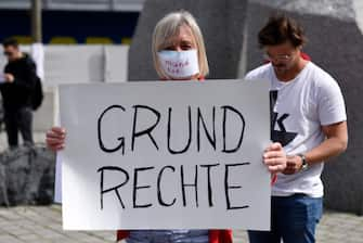 VIENNA, AUSTRIA - APRIL 24: A participant with a face mask reading "silenced" and a sign reading "fundamental rights" poses during a demonstration against the government measures to slow down the spread of coronvirus on April 24, 2020 in Vienna, Austria. The demonstration was forbidden to avoid possible COVID-19 infections. (Photo by Thomas Kronsteiner/Getty Images)