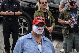 CARMEL, NY - MAY 25: A person wears a protective mask that reads "Trump 2020"  before participating in a car parade for Memorial Day on May 25, 2020 in Carmel, New York. Participants planned to honor those who died while serving in the military and show support for the reopening of Putnam county during the Covid-19 pandemic.  (Photo by Stephanie Keith/Getty Images)