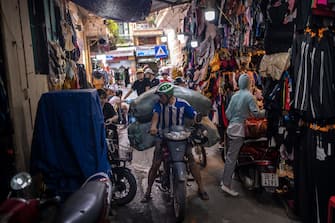 HANOI, VIETNAM - MAY 17: A delivery man tries to get through an alley packed with clothing stores in the Old Quarter on May 17, 2020 in Hanoi, Vietnam. Though some restrictions remain in place, Vietnam has lifted the ban on certain entertainment facilities and non-essential businesses, including pubs, cinemas and spas & other tourist attractions to recover domestic tourism. On April 23, the Ministry of Transport started to increase domestic flights and trains to major destinations with limited passenger capacity. As of May 17, Vietnam has confirmed 320 cases of coronavirus disease (COVID-19 ) with no deaths in the country, 260 fully recovered and no new case caused by community transmission for 31 days.