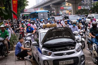 HANOI, VIETNAM - MAY 19: Motorbike riders with face masks are stuck in traffic during the morning peak hour on May 19, 2020 in Hanoi, Vietnam. Though some restrictions remain in place, Vietnam has lifted the ban on certain entertainment facilities and non-essential businesses, including pubs, cinemas and spas & other tourist attractions to recover domestic tourism. On April 23, the Ministry of Transport started to increase domestic flights and trains to major destinations with limited passenger capacity. As of May 19, Vietnam has confirmed 324 cases of coronavirus disease (COVID-19 ) with no deaths in the country, 263 fully recovered and no new case caused by community transmission for 33 days. (Photo by Linh Pham/Getty Images)