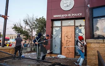 Protesters use a barricade to try and break the windows of the Third Police Precinct on May 28, 2020 in Minneapolis, Minnesota, during a protest over the death of George Floyd, an unarmed black man, who died after a police officer kneeled on his neck for several minutes. - Authorities in Minneapolis and its sister city St. Paul got reinforcements from the National Guard on May 28 as they girded for fresh protests and violence over the shocking police killing of a handcuffed black man. Three days after a policeman was filmed holding his knee to George Floyd's neck for more than five minutes until he went limp, outrage continued to spread over the latest example of police mistreatment of African Americans. (Photo by Kerem Yucel / AFP) (Photo by KEREM YUCEL/AFP via Getty Images)