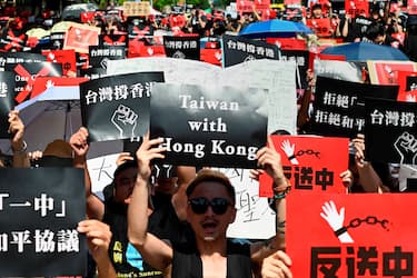 TOPSHOT - Protesters display placards during a demonstration in Taipei on June 16, 2019, in support of the continuing protests taking place in Hong Kong against a controversial extradition law proposal. - Tens of thousands of people rallied in central Hong Kong on Sunday as public anger seethed following unprecedented clashes between protesters and police over an extradition law, despite a climbdown by the city's embattled leader. (Photo by Sam YEH / AFP)        (Photo credit should read SAM YEH/AFP via Getty Images)