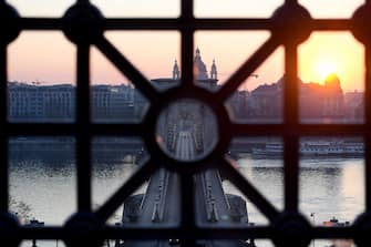 The sun rises behind the oldest Hungarian bridge, the 'Lanchid' (Chain Bridge) in Budapest on April 3, 2020, amid the new coronavirus / Covid-19 pandemic. - Hungary's parliament on Monday, March 30, 2020 approved a bill giving nationalist premier Viktor Orban sweeping powers he says are necessary to fight the new coronavirus pandemic but which critics have condemned as a power grab. (Photo by ATTILA KISBENEDEK / AFP) (Photo by ATTILA KISBENEDEK/AFP via Getty Images)