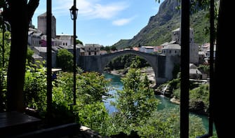 TOPSHOT - The deserted "Old Bridge" of Mostar, usually riddled with groups of tourists is seen from an empty restaurant terrace, on May 8, 2020. - With more than 90 percent of those tourists foreigners, the town is now facing a particularly painful collapse as the COVID-19 pandemic caused by the novel coronavirus, shutters international borders and severely curbs air travel, sending the global tourism industry into a tailspin. (Photo by ELVIS BARUKCIC / AFP) (Photo by ELVIS BARUKCIC/AFP via Getty Images)