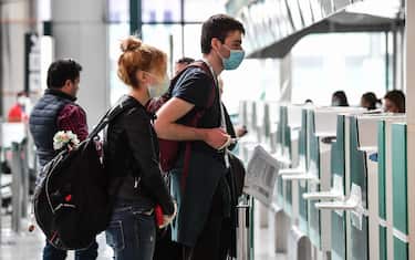 Passengers wearing a respiratory mask wait for check-in at the Terminal T1 of Rome's Fiumicino international airport on March 13, 2020. - Rome's Ciampino airport will shut to passenger flights from March 13, authorities said, with a Terminal T1 also closing at the city's main Fiumicino facility next week as airlines slash flights to Italy over the coronavirus outbreak. (Photo by Andreas SOLARO / AFP) (Photo by ANDREAS SOLARO/AFP via Getty Images)