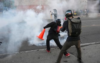 USA MINNESOTA GEORGE FLOYD DEATH PROTEST epa08455583 A protester deflects a teargas canister with a traffic cone as they demonstrate during the fifth day of protests over the arrest of George Floyd, who later died in police custody, in Minneapolis, Minnesota, USA, 30 May 2020. A bystander's video posted online on 25 May, appeared to show George Floyd, 46, pleading with arresting officers that he couldn't breathe as an officer knelt on his neck. The unarmed black man later died in police custody. EPA/CRAIG LASSIG