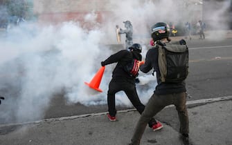 epa08455583 A protester deflects a teargas canister with a traffic cone as  they demonstrate during the fifth day of protests over the arrest of George Floyd, who later died in police custody, in Minneapolis, Minnesota, USA, 30 May 2020. A bystander's video posted online on 25 May, appeared to show George Floyd, 46, pleading with arresting officers that he couldn't breathe as an officer knelt on his neck. The unarmed black man later died in police custody.  EPA/CRAIG LASSIG