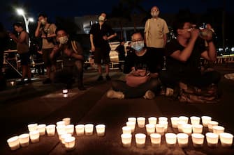 People sit behind candles in front of the Chiang Kai-shek Memorial Hall, also known as Free Square, to mark the 31st anniversary of the 1989 Tiananmen Square crackdown in Taipei in June 4, 2020. (Photo by Sam Yeh / AFP) (Photo by SAM YEH/AFP via Getty Images)